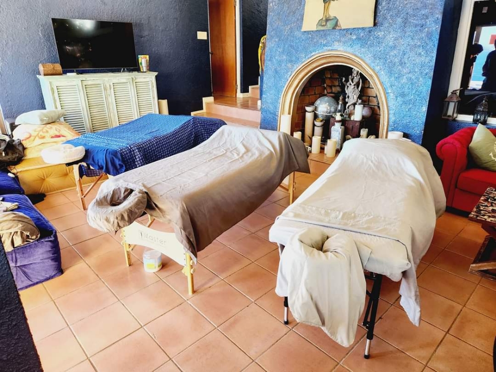 Couples massage in a Caribbean living room with fireplace and candles