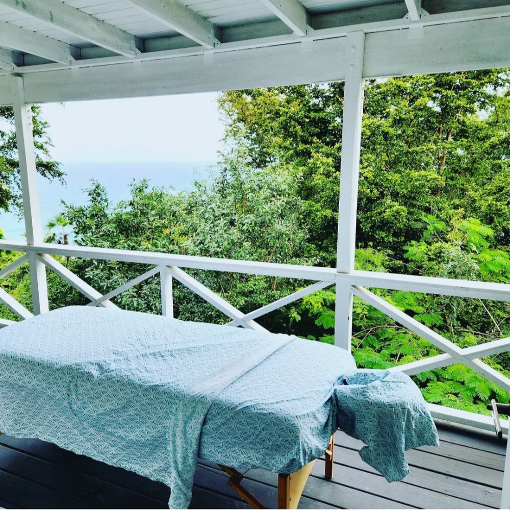 Massage table set on a porch with tropical forest view